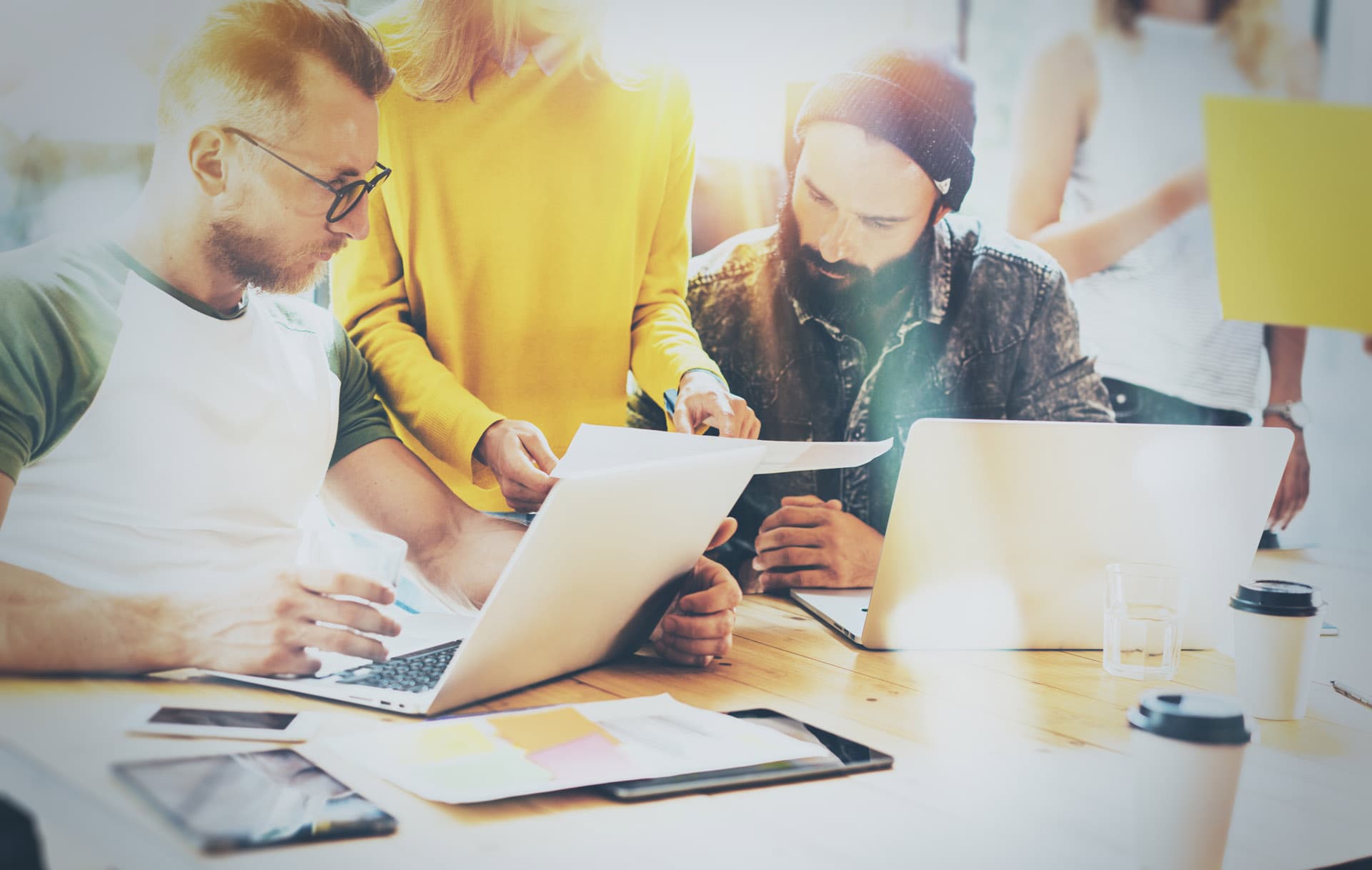 Eine Gruppe von Personen, die gemeinsam auf dem Laptop arbeiten