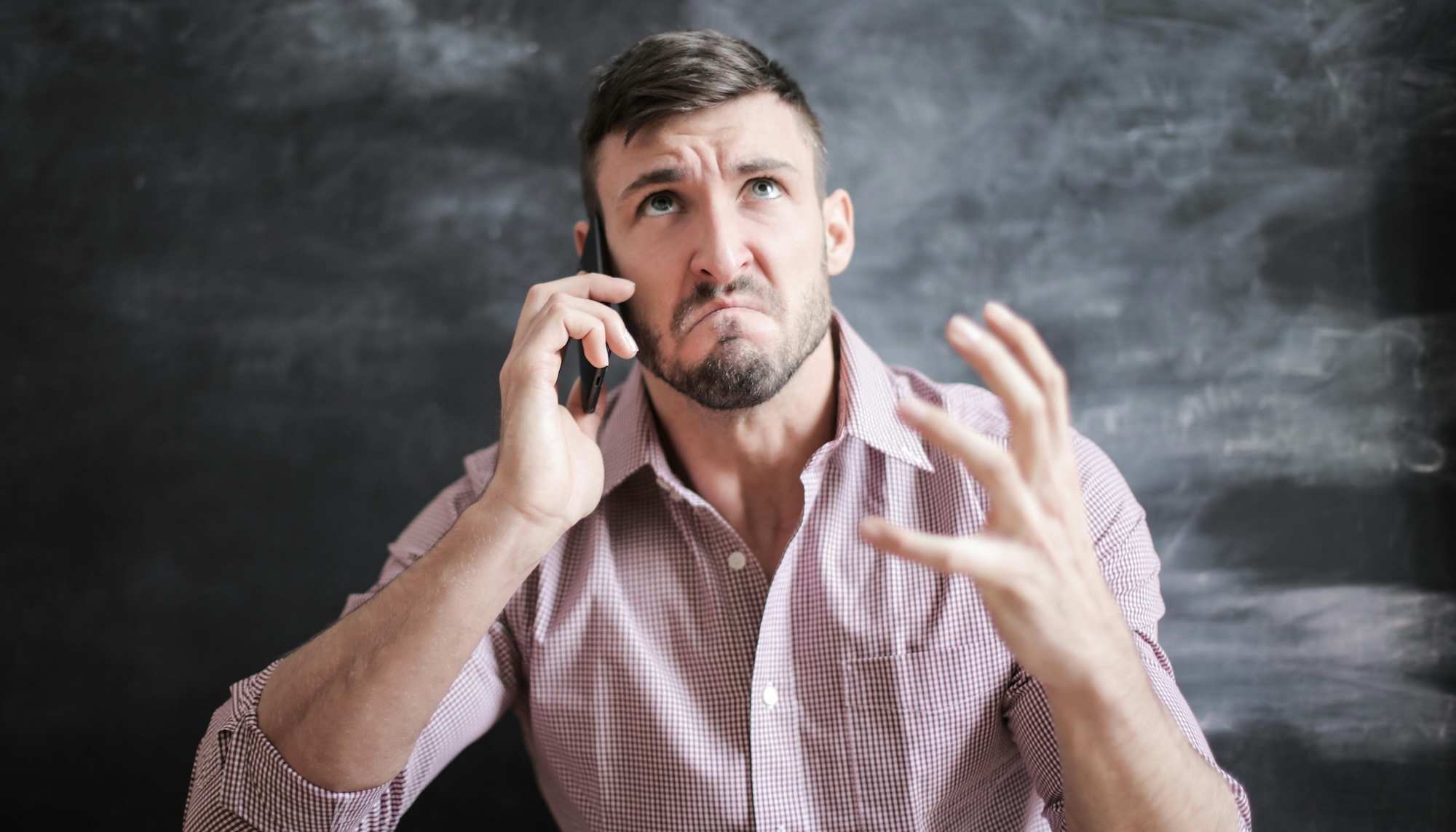 A man on the phone, looking angry and sad